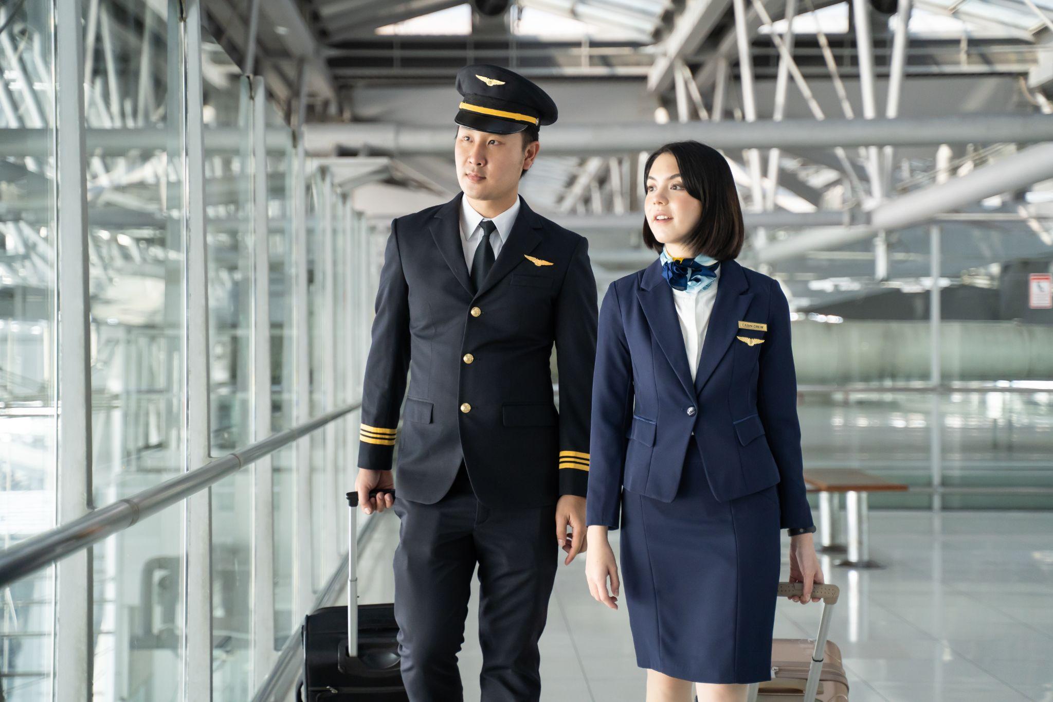 airliner pilot and air hostess walk together in airport terminal.
