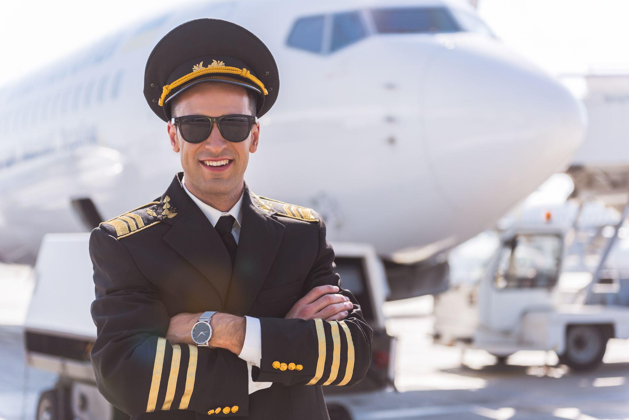 Smiling pilot captain with arms crossed.